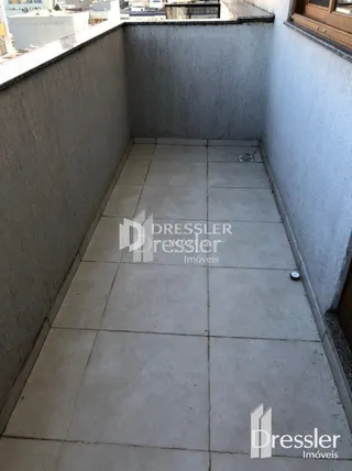 Corredor interno com piso de cerâmica clara.