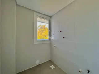 Vista de um corredor interno com paredes brancas e piso de carpete.