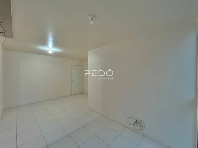 Interior de uma sala com piso de cerâmica branca e paredes brancas.