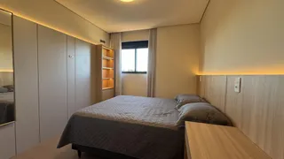 Quarto com cama e armários em um ambiente claro com iluminação natural.