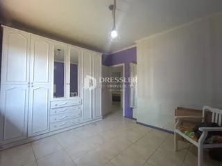 Quarto com armários brancos e piso de cerâmica claro.