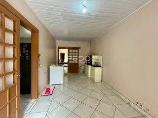 Corredor interno de uma residência com piso de cerâmica clara.