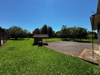 Vista externa mostrando um gramado verde e uma área de cascalho.