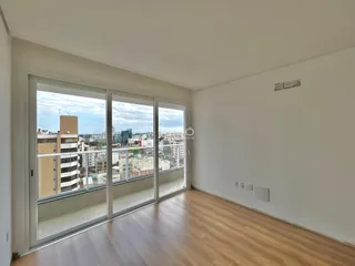 Sala de estar com piso de madeira e vista da paisagem urbana.