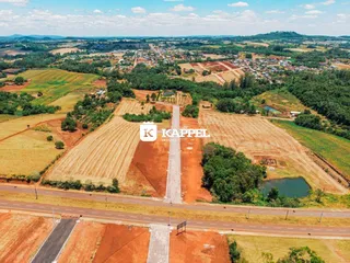Vista aérea de uma propriedade rural com campos agrícolas e vegetação no interior de Lajeado.
