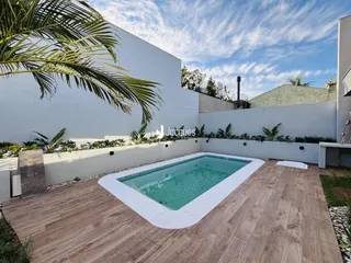 Foto da área externa com piscina e deck de uma propriedade.