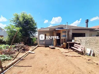 Fachada de uma casa em Lajeado, Brasil, com terreno de terra em frente.