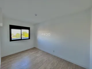 Sala de estar com piso de madeira e janela.