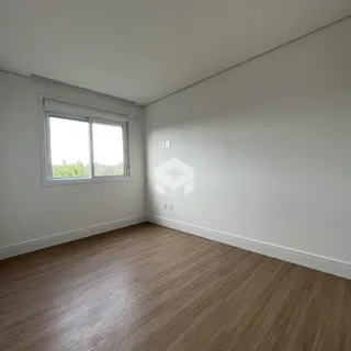 Uma sala interna com piso de madeira e janela.