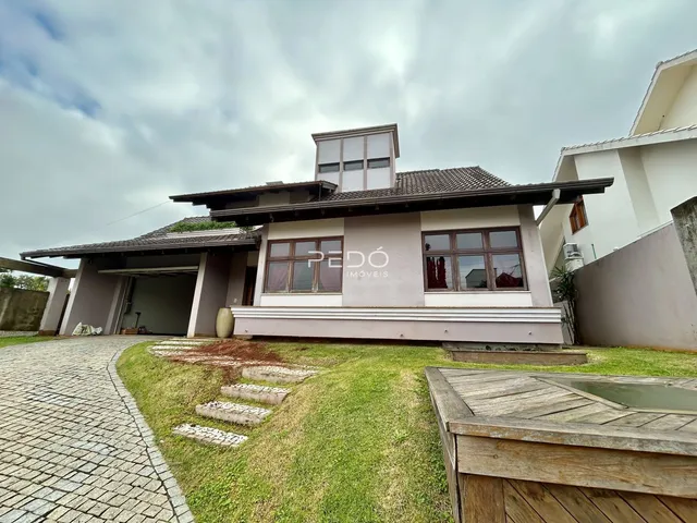 Fachada de uma casa em Lajeado, Brasil, com jardim e entrada pavimentada.