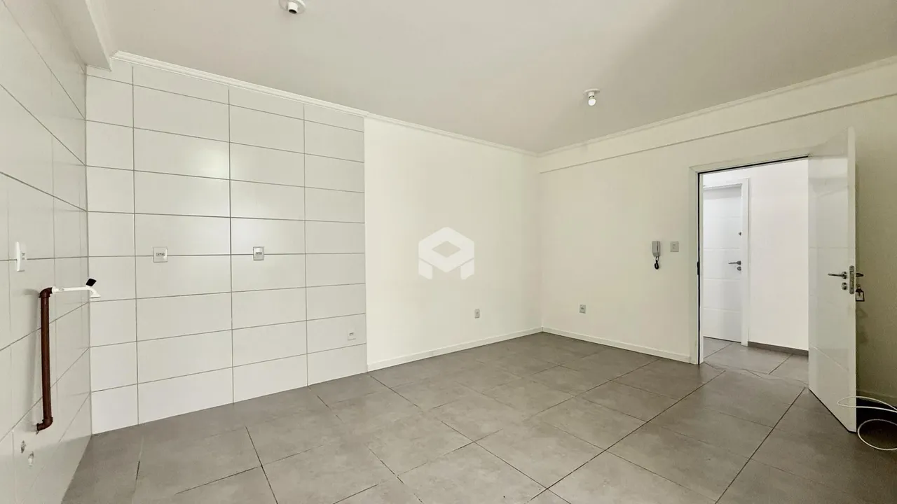 Interior de um ambiente com paredes brancas e piso cinza claro.