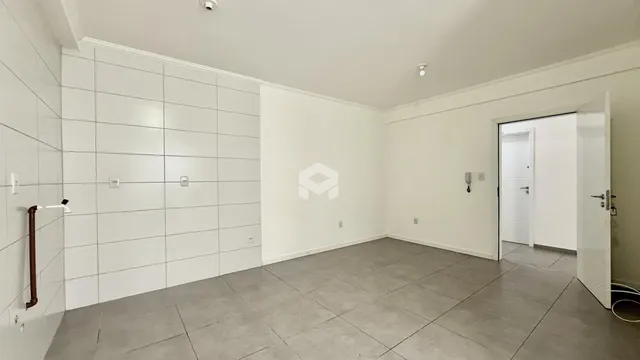 Interior de um ambiente com paredes brancas e piso cinza claro.