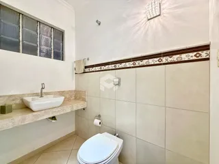 Foto interna de um banheiro com revestimento de cerâmica e pia.