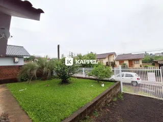 Fachada de uma residência com jardim e cerca branca em Lajeado, Brasil.