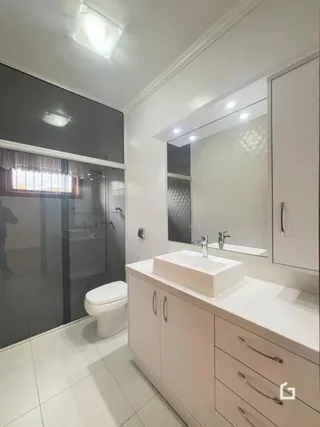 Foto de um banheiro moderno com louças brancas e revestimento de azulejo.