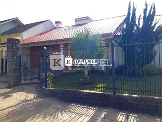 Foto da fachada de uma residência em Lajeado, Brasil, com cerca e jardim.