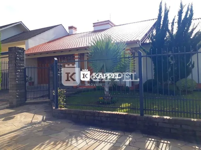 Foto da fachada de uma residência em Lajeado, Brasil, com cerca e jardim.