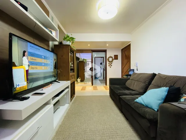 Sala de estar com sofá e televisão em um apartamento no Brasil.