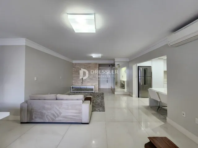 Sala de estar com sofá e piso claro em um imóvel no Brasil.