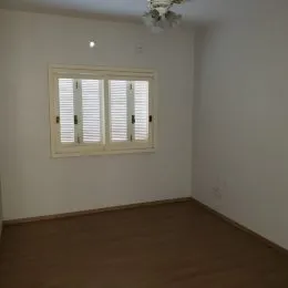 Foto de um cômodo interno com piso de madeira e janela.