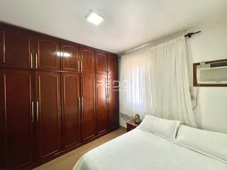 Quarto com armários de madeira e cama em um imóvel no Brasil.