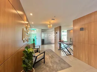 Hall de entrada moderno com painéis de madeira e piso claro.
