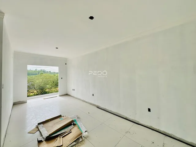 Interior de um espaço com paredes brancas e piso claro.