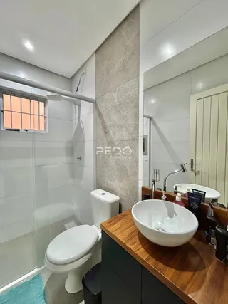A foto mostra um banheiro moderno com vaso sanitário e pia.