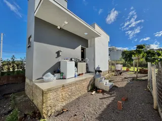 Vista externa de uma casa moderna com fundação de concreto e quintal de cascalho.