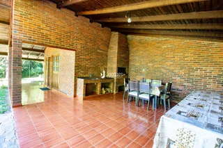 Ambiente interno com paredes de tijolo aparente e piso de cerâmica vermelha.
