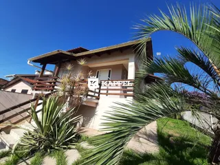 Fachada de uma residência em Lajeado, Brasil, com vegetação tropical em primeiro plano.