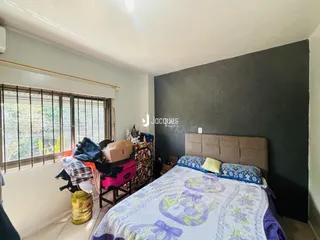 Quarto com grande janela e cama decorada.