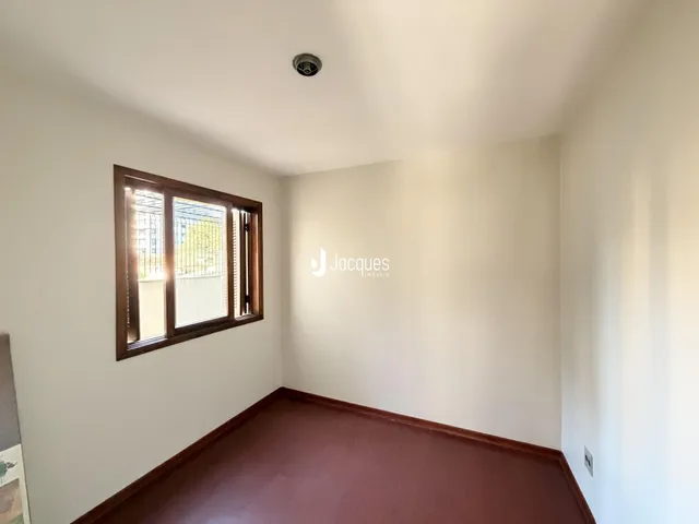 Foto de um cômodo interno com parede clara e piso marrom na Lajeado.