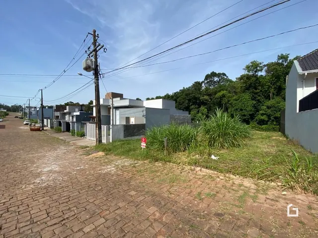 Vista externa da propriedade com gramado e poste de luz na frente.