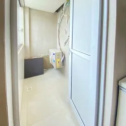 Hall de corredor com paredes brancas e fiação visível.