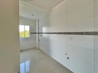 Hall de entrada com piso claro e paredes brancas.