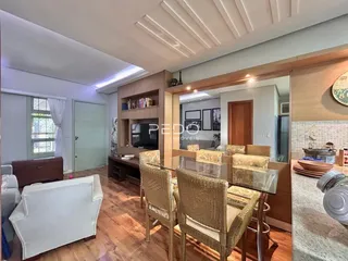 Sala de estar com piso de madeira e móveis de jantar em um imóvel no Brasil.