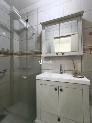 Foto de um banheiro com box de vidro e bancada de mármore.