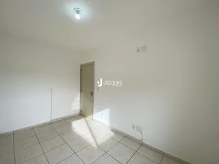 Interior de um cômodo com piso de cerâmica e porta branca.