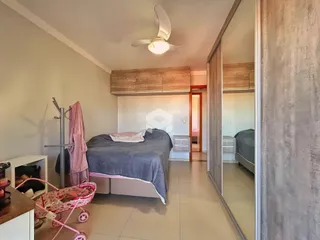 Quarto com cama e armário em ambiente claro.