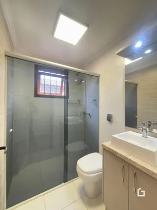 Foto de um banheiro moderno com box de vidro e vaso sanitário.