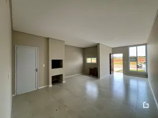 Ambiente interno de uma sala ampla com piso de cerâmica e paredes claras.