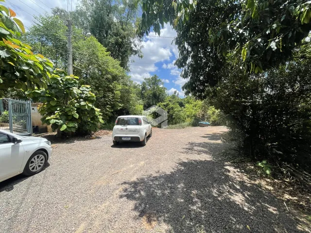 Vista da entrada de uma propriedade em Lajeado, Brasil, com vegetação densa ao redor.