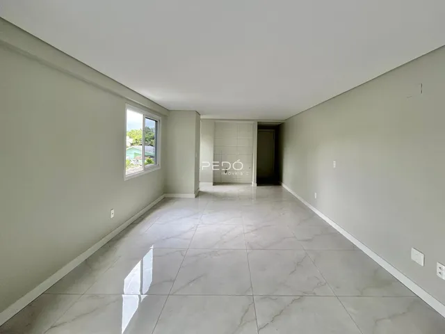 Hall de entrada com piso de porcelanato claro e paredes brancas.