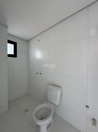 Foto de um banheiro com paredes brancas e piso claro.