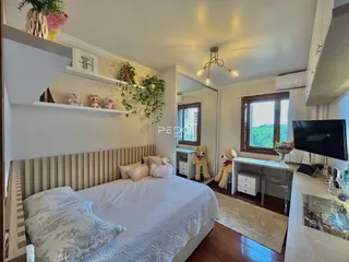 Quarto com cabeceira de madeira e decoração de parede em Lajeado.