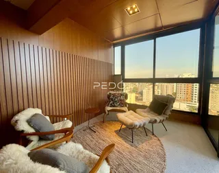 Sala de estar com decoração moderna e vista para a paisagem urbana.