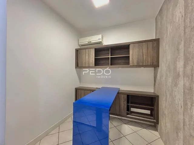 Interior de um ambiente com armários de madeira e piso claro.