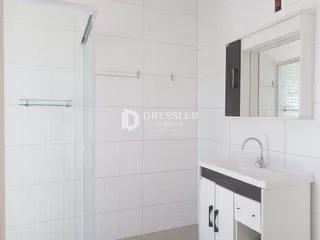 Foto de um banheiro com revestimento branco e box de vidro.