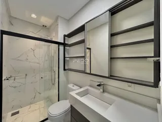 Foto de um banheiro com box de vidro e revestimento de mármore.